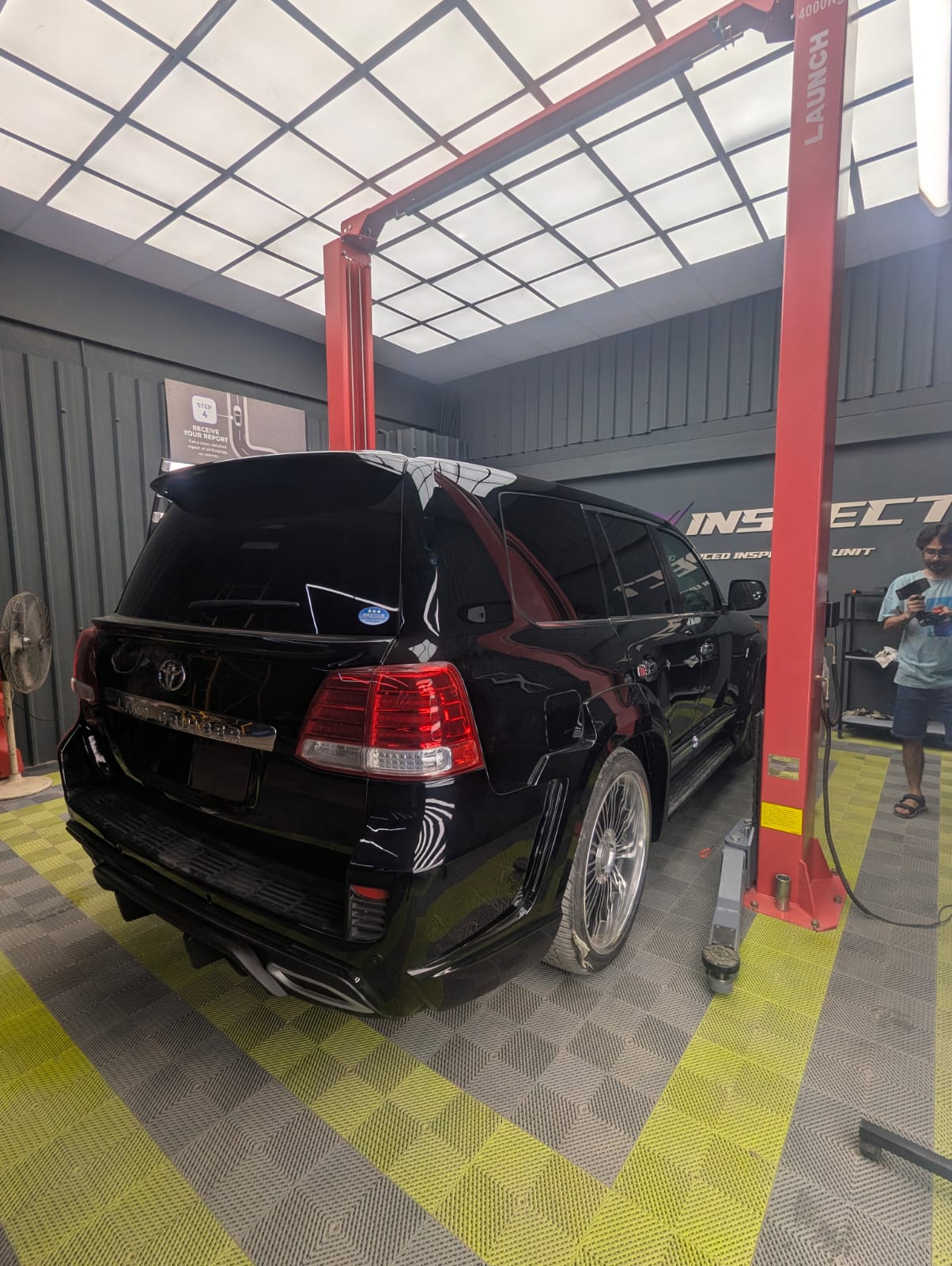Automotive diagnostic tablet connected to a luxury vehicle interior during a lab-grade inspection